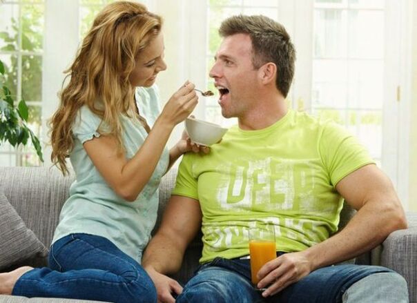 a woman feeding a man products to increase potency